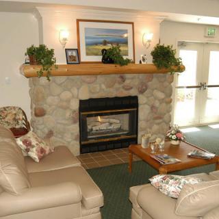 A cozy living room with a stone fireplace, leather couches, and tasteful decorations.