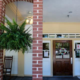 A welcoming entrance featuring a brick facade and a hanging fern.