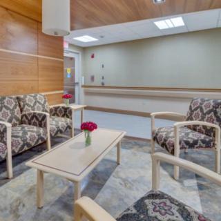 A modern waiting room with patterned seating and a simple wooden table.