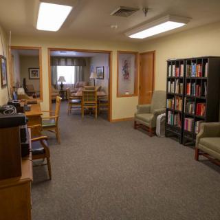 A cozy office space with a bookshelf and comfortable seating.