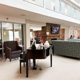 A modern lounge area featuring a piano and comfortable seating.