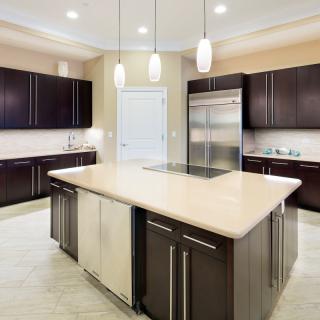 A modern kitchen with dark cabinets and a central island.