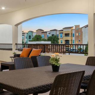 A cozy outdoor patio with wicker furniture overlooking colorful apartment buildings.