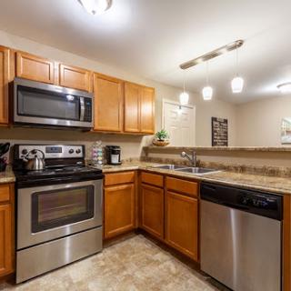 A contemporary kitchen featuring modern appliances and wooden cabinetry.