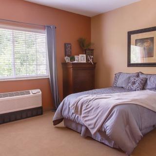 A cozy, well-decorated bedroom with a comfortable bed and natural light streaming through the window.