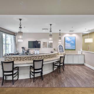 A modern reception area featuring a curved counter, stylish chairs, and elegant lighting.