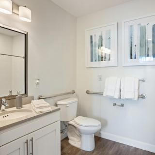 Modern bathroom with sink, toilet, and wall-mounted towels