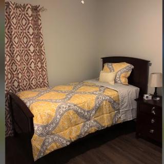 A cozy bedroom with a single bed and yellow bedding.