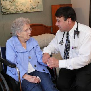 A doctor consulting with an elderly patient in a healthcare setting.
