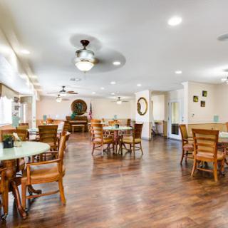 A spacious and welcoming dining area featuring wooden furniture and bright lighting.