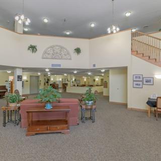 A spacious lobby area with comfortable seating, plants, and a reception desk.