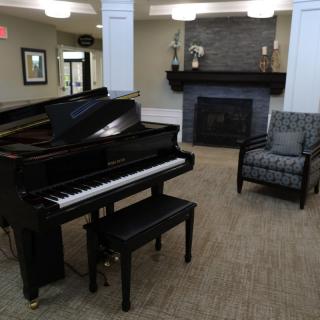 A cozy living room with a grand piano and fireplace.