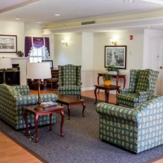 A cozy living room with patterned armchairs and wooden coffee tables.