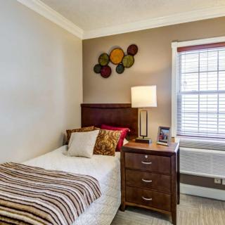 A cozy bedroom with a single bed, nightstand, and decorative wall art.