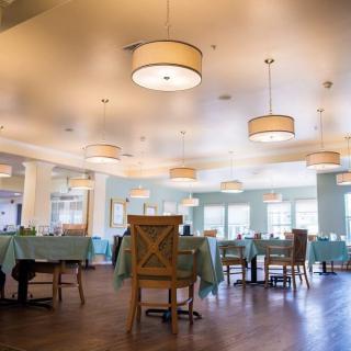 An empty restaurant dining area with neatly arranged tables and chairs.
