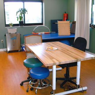 A cozy and functional workspace featuring a wooden table and ergonomic chairs, complemented by green walls and natural light.