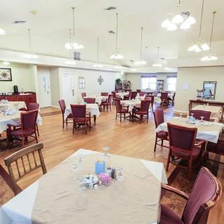 An empty dining room with neatly arranged tables and chairs, ready for guests.