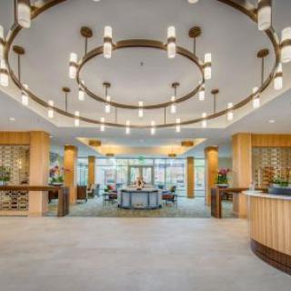 A modern, spacious lobby with elegant circular chandeliers and a reception desk.