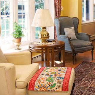 A cozy living room with comfortable seating, a classic lamp, and decorative accents.