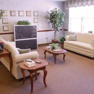 A cozy living room with beige sofas, a television, and wooden coffee tables.