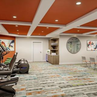 A modern gym interior featuring exercise equipment, vibrant ceiling color, and stylish decor.