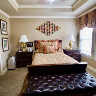 A traditionally styled bedroom with a bed, nightstands, and decorative elements.