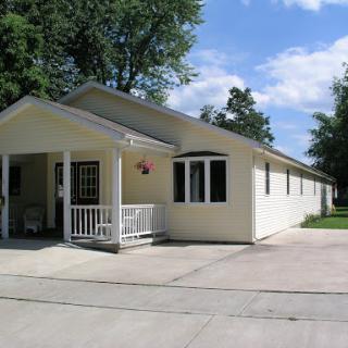 A charming single-story house featuring a welcoming front porch.