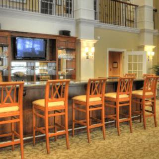 Modern bar area with wooden stools and a television.