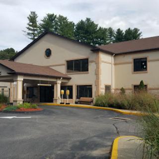 A modern commercial building featuring a welcoming entrance and landscaped surroundings.