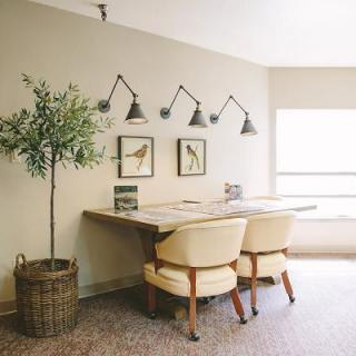 A cozy home office setup with a shared desk, comfortable chairs, and stylish decor.