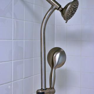 Modern showerhead with a sleek design installed on tiled wall.