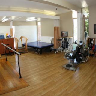 A well-equipped rehabilitation room with exercise machines and therapy tools.