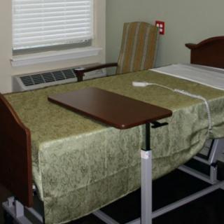 A hospital room featuring a bed with a bedside table.