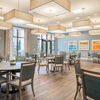 A modern dining area with stylish lighting fixtures and arranged seating.