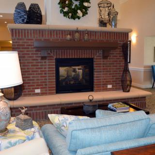 A cozy living room with a brick fireplace and comfortable seating.
