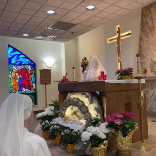 A serene moment of worship at the altar, adorned with flowers and a stained glass window.