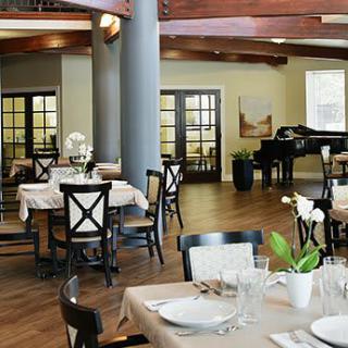 Elegant restaurant dining area with neatly set tables and a grand piano.