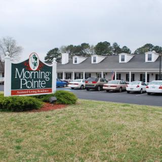 A view of a building with a parking lot and a sign reading 'Morning Pointe'.