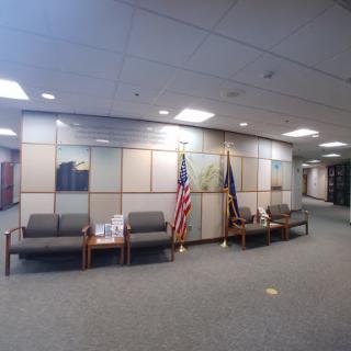 A spacious waiting area in an office featuring seating and American flags.