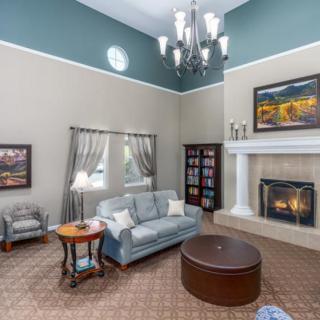 A well-decorated living room featuring a cozy sofa, elegant chandelier, and a warm fireplace.