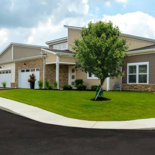 A suburban house with a well-maintained lawn and driveway.