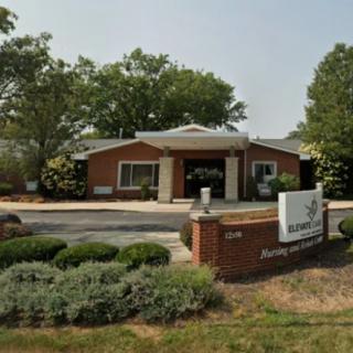 A brick building with landscaped surroundings and a prominent entrance sign.
