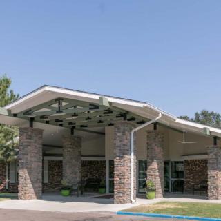 A modern building with a unique architectural entrance and landscaping.