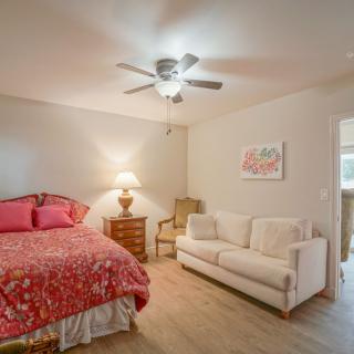 Cozy bedroom with a bed, sofa, and ceiling fan.