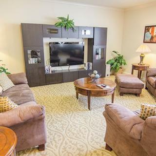 A cozy living room with comfortable sofas, a central coffee table, and an entertainment center featuring a large television.