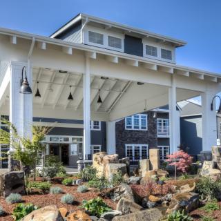 A modern building with a landscaped entrance and a large covered entryway.