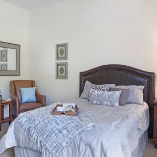 A cozy bedroom with a neatly made bed and stylish decor.