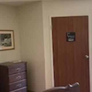 An interior office space with a wooden door and furniture.
