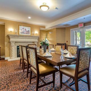 A well-appointed dining room with elegant furnishings, featuring a fireplace and large table surrounded by chairs.