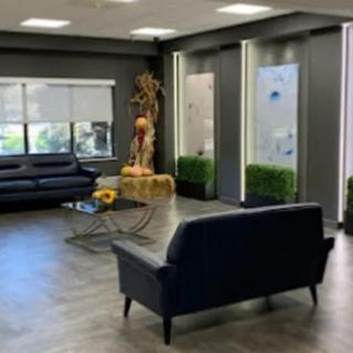 A modern waiting area with black sofas and minimalist decor.